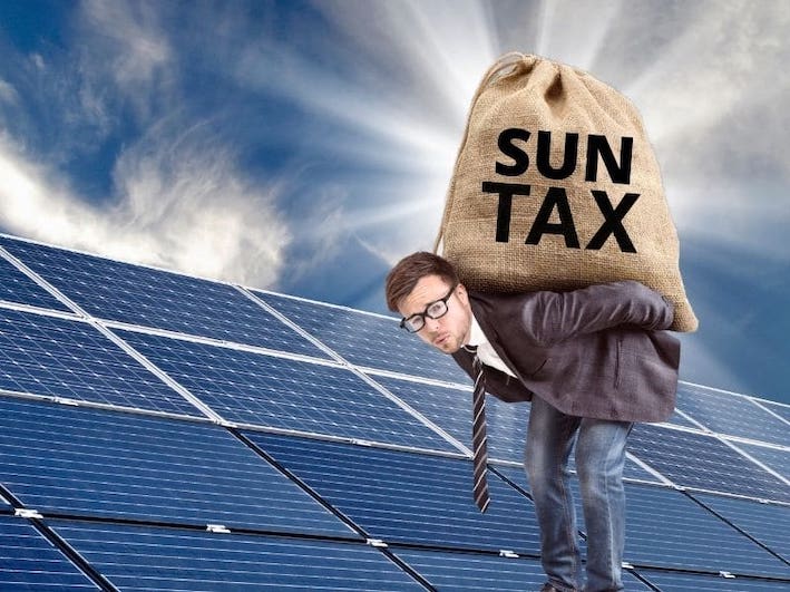 Man carrying a heavy 'Sun Tax' sack in front of solar panels, illustrating the financial burden of new solar levies on homeowners and businesses.